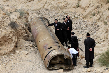 Judíos ultraortodoxos se reúnen alrededor de partes de un misil balístico iraní descubierto por excursionistas israelíes cerca de la ciudad sureña de Arad.