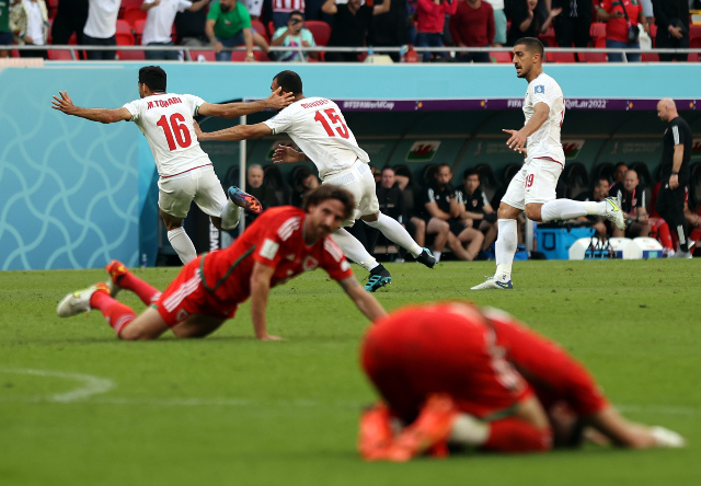 Los jugadores de Irán celebrando los goles de la victoria (0-2) en los últimos minutos del encuentro frente a Gales. También se ve la tristeza de los europeos al perder su primer partido en la Copa Mundial. 