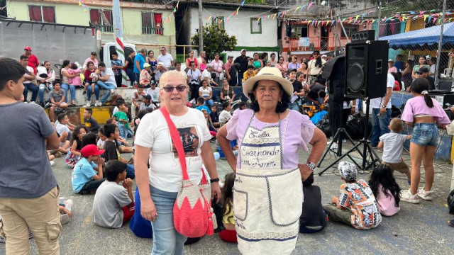 Estelia Vélez en el barrio Pablo VI de Anserma, acompañada por personas que la ayudan en su labor.