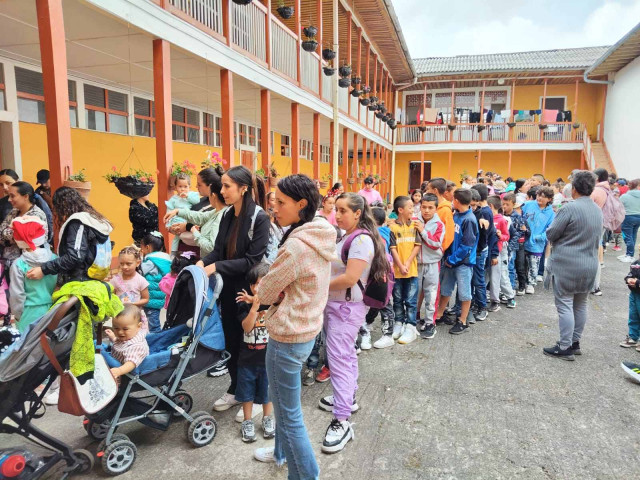 Fila en colegio de San Félix de personas esperando el regalo de Navidad.