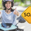 Mujer en moto al lado de un aviso que dice "SOAT"