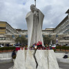 Velas y flores a los pies de la escultura de Juan Pablo II a las puertas del Hospital Gemelli de Roma donde permanece ingresado el papa Francisco.