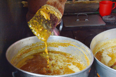 El proceso de elaboración consiste en mezclar 4 libras de panela, 7 litros de leche, ralladura de naranja, luego con el mecedor se revuelve durante tres horas en el fogón de leña hasta llegar al punto para luego armar las bolitas de panela.