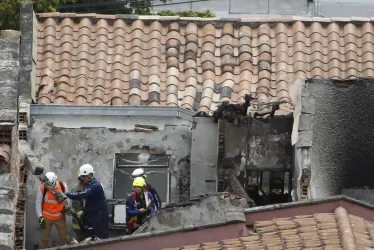 Bomberos y organismos de socorro llegan para atender la emergencia, luego de que una avioneta se estrellara en un barrio residencial hoy en Medellín