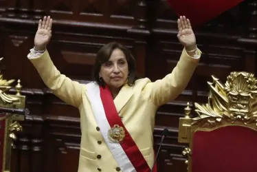La abogada Dina Boluarte saluda tras ser juramentada como nueva presidenta del Perú.