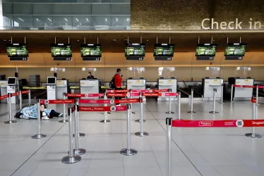 Personas esperan hoy, en el aeropuerto El Dorado, tras el cierre de operaciones de la aerolínea Viva Air, en Bogotá.