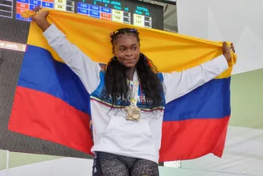 Ingrid Segura celebra con la bandera de Colombia las dos medallas que ganó en el Panamericano de Pesas que se cumple en Manizales. 