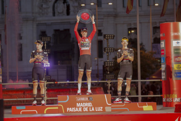 Los ciclistas del Jumbo Visma, el estadounidense Sepp Kuss (centro), el danés Jonas Vingegaard (izquierda) y el esloveno Primoz Roglic, durante la entrega de los trofeos como primero, segundo y tercer clasificados respectivamente de la clasificación general de la Vuelta a España, que finalizó este domingo en Madrid.