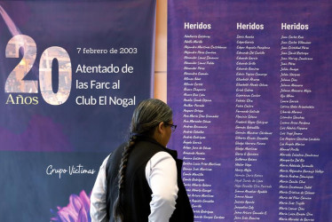 Una visitante observa una pieza gráfica con la lista de víctimas del atentado al club El Nogal hoy, en la sede de la Jurisdicción Especial para la Paz (JEP), en Bogotá.