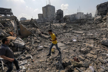 Palestinos caminan entre los escombros tras un ataque a la zona de Al-Ramal, tras un ataque israelí, este martes en la Ciudad de Gaza.