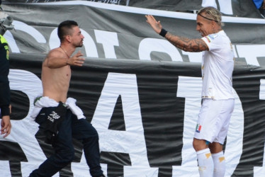 La celebración de Dayro Moreno con un aficionado que saltó a la pista atlética. Con su gol, del Once Caldas le ganó 2-1 al Boyacá Chicó.