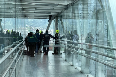 Un técnico intenta activar el ascensor para sacar a las personas. Bomberos acompañan el procedimiento de rescate. 