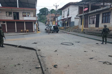 Fotografía cedida por las Fuerzas Militares de Colombia, de militares mientras vigilan junto a un carro que explotó este viernes en el corregimiento de Robles, Jamundí (Valle del Cauca).