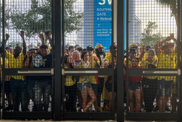 Aficionados esperan a las afueras del estadio Hard Rock este domingo previo a la final de la Copa América en Miami (Estados Unidos). Una avalancha de decenas de aficionados con camisetas de la selección de Colombia y algunos de Argentina en una de las puertas de ingreso al estadio Hard Rock de Miami obligó a las autoridades a horas del comienzo de la final de la Copa América, a cerrar temporalmente el acceso de todo el escenario.