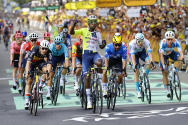 El ciclista eritreo Biniam Girmay (c) de Intermarche-Wanty celebra mientras cruza la línea de meta para ganar la tercera etapa de la carrera ciclista Tour de Francia 2024 de 230 km desde Piacenza hasta Turín (Italia).