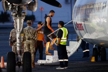 Un migrante sube a un avión para ser deportado a Colombia. 