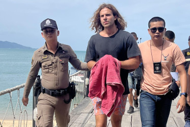 El chef español Daniel Sancho Bronchalo (c) es escoltado por agentes de policía tailandeses cuando llegan a un puerto antes de acudir al tribunal en la isla de Koh Samui, en el sur de Tailandia, el 7 de agosto de 2023 (reeditado el 29 de agosto de 2024).