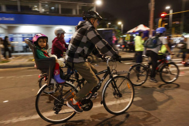 Las personas se movilizan en bicicleta, durante una jornada de ciclovía nocturna. 