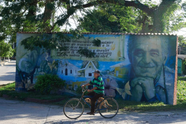 Un hombre en bicicleta pasa frente a un mural con la imagen del escritor Gabriel García Márquez. 