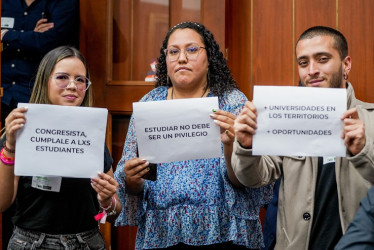 Estudiantes universitarios piden con letreros que se le cumplan a la educación. 