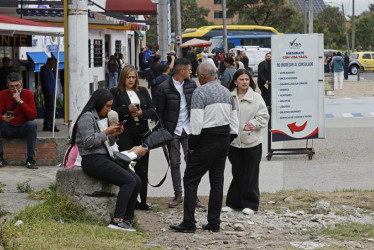 Ciudadanos colombianos solicitantes de visa de los Estados Unidos esperan información este lunes, cerca a la sede de la embajada de los Estados Unidos en Bogotá (Colombia).