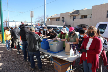 Fotografía de archivo del 23 de diciembre de 2022 donde aparecen inmigrantes recibendo ayuda cerca de un albergue en El Paso, Texas (EE.UU.).