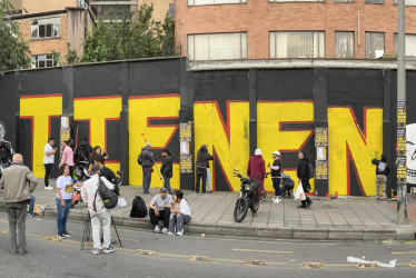 Fotografía panorámica de integrantes de colectivos artísticos pintando un grafiti este viernes, en Bogotá. 