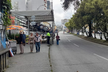 Una mujer cruza frente al palco ubicado en la antigua sede de Bavaria, sobre la avenida Santander, momentos antes de que pase el desfile de las Carretas del Rocío de la Feria de Manizales.