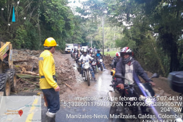 Vehículos pasan por el carril habilitado en la vía Manizales-Neira, al lado del derrumbe en el sector Fogón de Palo.